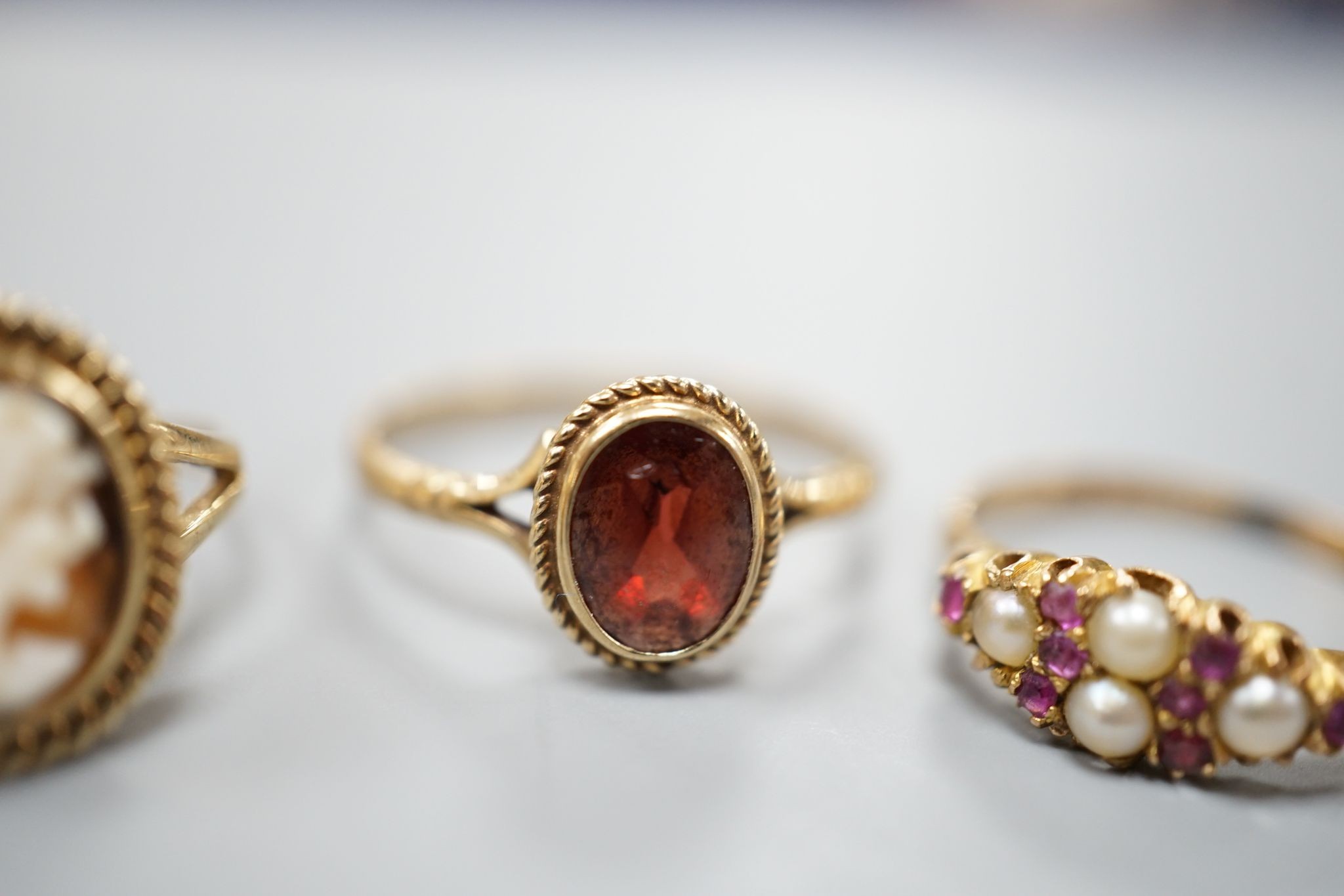 A late Victorian 15ct gold, seed pearl and amethyst cluster set ring, size L, gross 2.1 grams and two later 9ct gold rings including cameo shell, gross 3.2 grams.